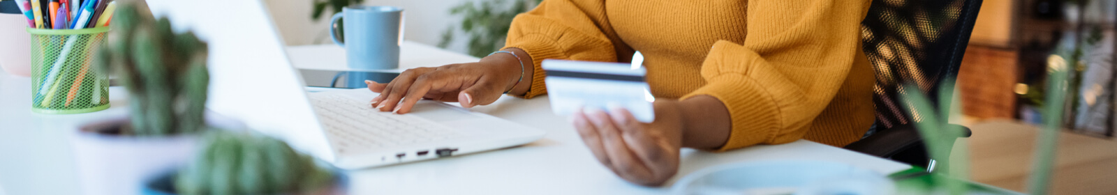 woman holding a credit card and using a laptop